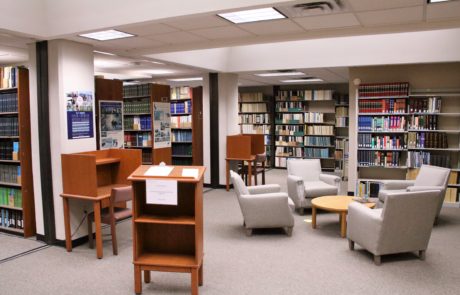 Seating for collaborative working groups surrounded by shelves holding the collection.